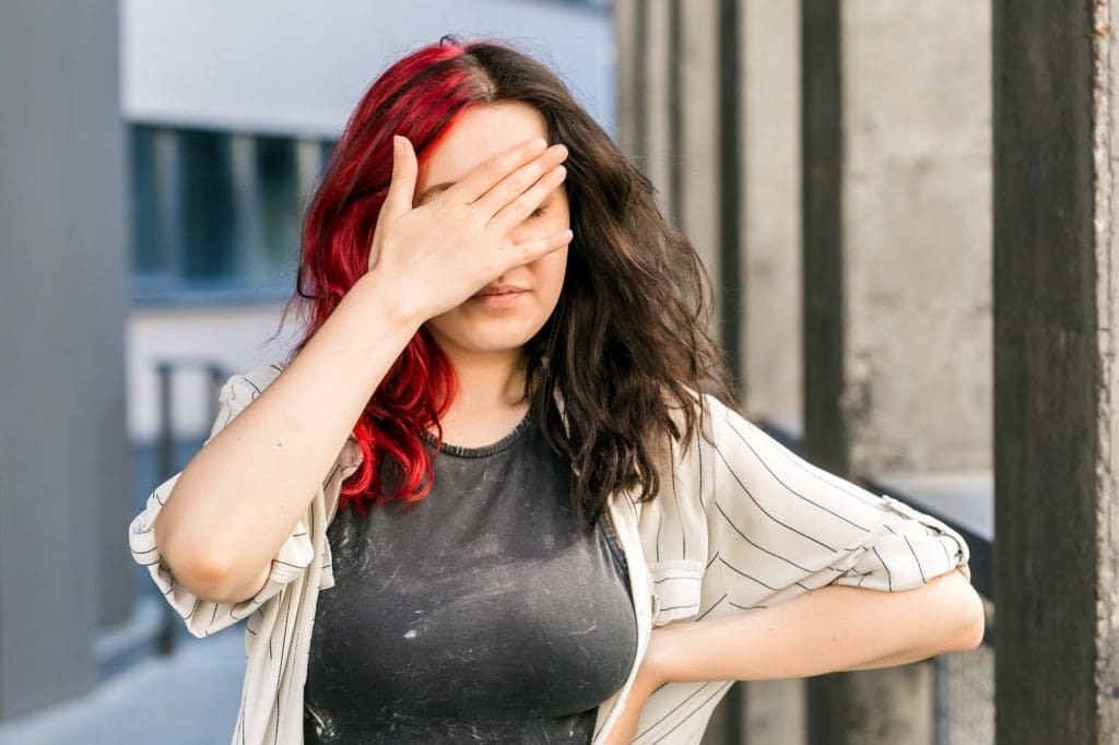 Stylish woman making face palm gesture with hand